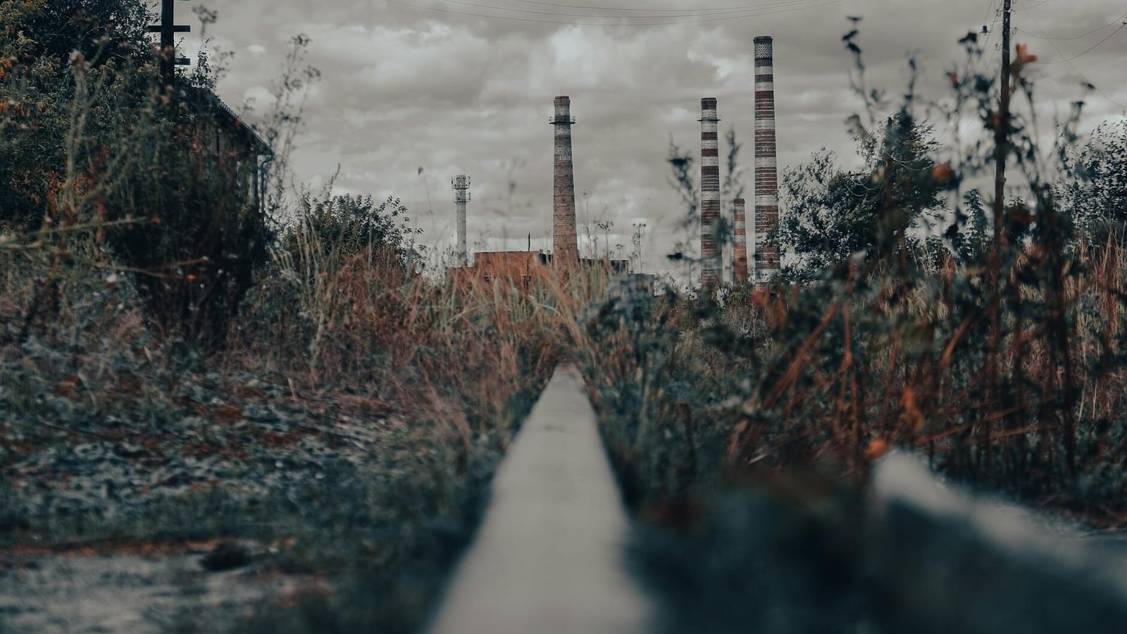 industrial chimneys near grass field